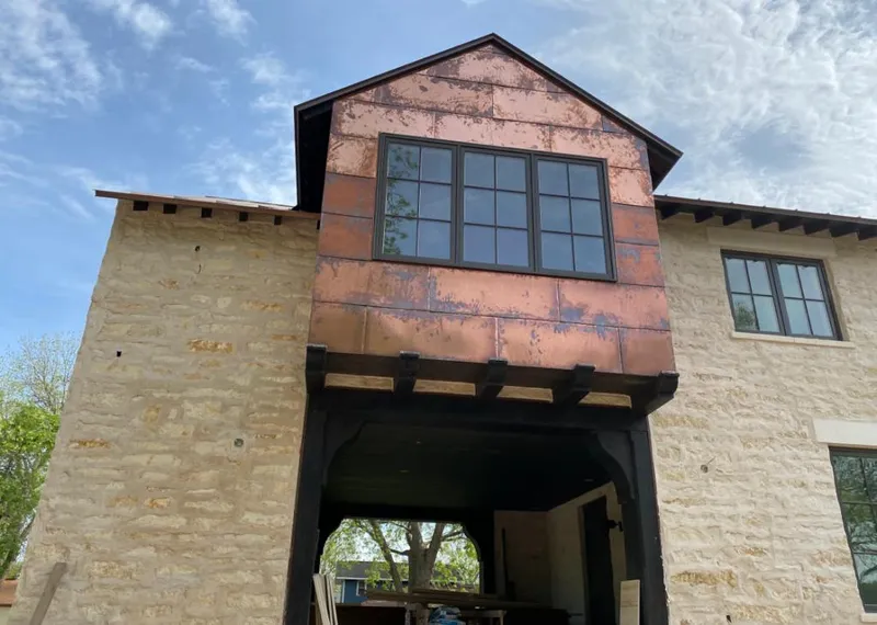 Copper metal panel facade on a stone building for Roof Repair in Johns Creek