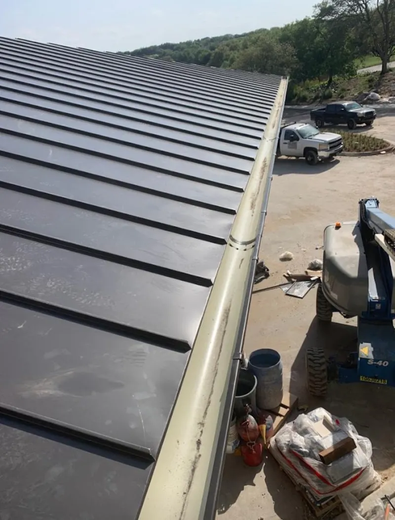 Standing seam panel and gutter detail on a metal roofing jobsite in Johns Creek